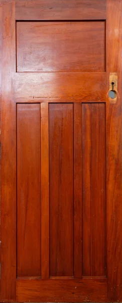A wooden panel door has had its door handle removed and is waiting to be sanded back before being rehung.