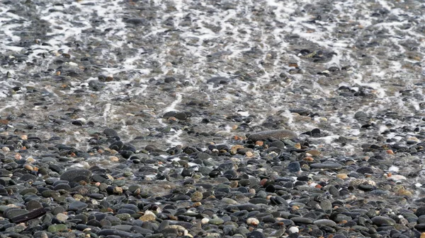 Skummet Från Våg Rullar Tillbaka Över Småsten Stranden Väg Tillbaka — Stockfoto