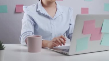 Bilgisayarda çalışan Asyalı kadın, ev ofisinde otururken vücut ağrısı yüzünden hastaydı..