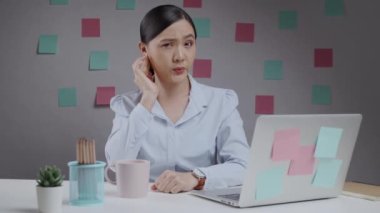 Ofiste çalışan Asyalı kadın boğazı ağrıyordu ve dirseğinde öksürük vardı..