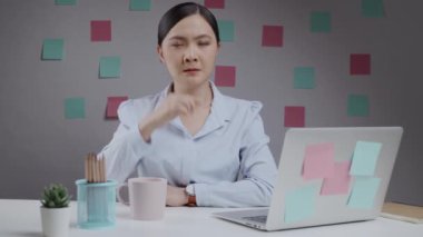 Ofiste çalışan Asyalı kadın boğazı ağrıyordu ve dirseğinde öksürük vardı..