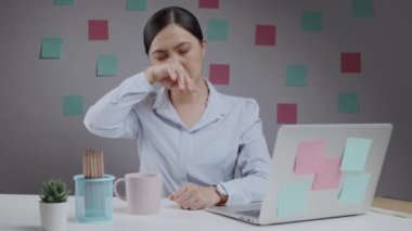 Ev ofisinde dizüstü bilgisayarda çalışan Asyalı kadın nefes nefese kalmış ve hastaydı..