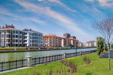 Afyon, Afyonkarahisar, Türkiye 'de modern evler, nehir ve çiçek açan kiraz ağaçları