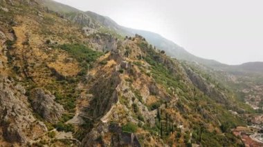 İnsansız hava aracı, Kotor 'un üstündeki eski kaleye giden zikzaklı yürüyüş yolunu takip ediyor.
