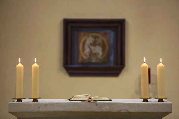 Bible and candles on altar.  France.