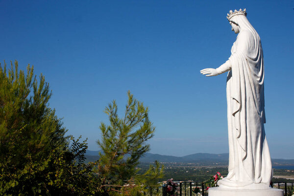 Virgin Mary statue against blue sky.  France. 