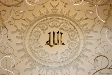 Şeyh Zayed Büyük Cami. Allah 'ın 99 adı (nitelik), geleneksel Kufi kaligrafisi kullanılarak Kibla duvarında yer almaktadır ve fiber optik aydınlatma kullanılarak ince bir şekilde aydınlatılmaktadır. Birleşik Arap Emirlikleri.