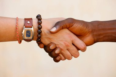 Afrikalı çocuk ve beyaz beyaz kadın arasında el ele tutuşmak. Çok ırklı bir tokalaşma. Togo.