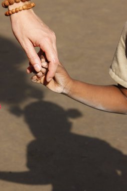 Afrikalı çocuk ve beyaz beyaz kadın arasında el ele tutuşmak. Evlat edinme. Togo.
