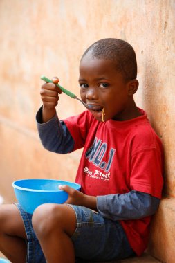 Genç Afrikalı çocuk öğle yemeği yiyor. Afrika 'da günlük yaşam. Togo.