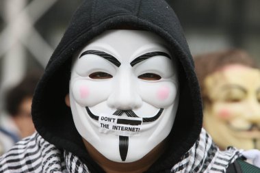 Guy Fawkes maskesi takan protestocu, Anonim Hareketi 'nin markası ve Vendetta' nın V 'sindeki bir karaktere dayanıyor. Fransa. 