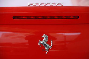 Kırmızı bir arabanın üzerindeki Ferrari beygir logosu. Katar. 
