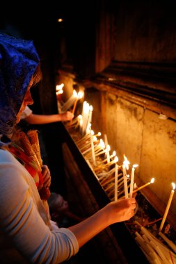 Kutsal Mezar Kilisesi. Pilgrim kilise mumlarını yakıyor. İsrail. 
