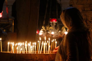 Kutsal Mezar Kilisesi. Pilgrim kilise mumlarını yakıyor. İsrail. 