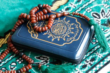 Kuran ve İslami dua boncukları bir paspasın üzerinde. İslam. 