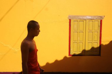  Wat Si Muang (Simuong) Budist tapınağı. Gün batımında pencerenin önündeki Budist keşiş. Vientiane. Laos. 