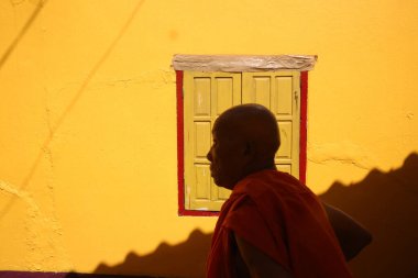  Wat Si Muang (Simuong) Budist tapınağı. Gün batımında pencerenin önündeki Budist keşiş. Vientiane. Laos. 