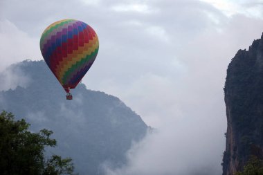 Vientiane Eyaleti. Yağmur mevsimi. Moutain, siyah bulutlar ve sıcak hava balonu. Vang Vieng. Laos. 