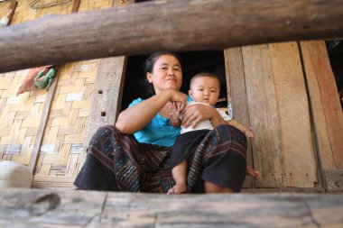 Geleneksel lao köyü. Bebekli bir kadın. Laos. 