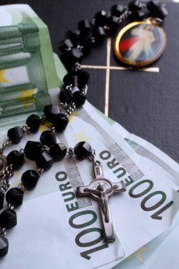 Para ve din. Dua boncukları, incil ve avro. 