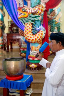Cao Dai tapınağı. Cao Dai 'ye tapan yüzükler şarkı söylüyor. Phu Quoc. Vietnam.