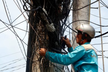 Elektrik direğini tamir eden tamirci. Cai Be. Vietnam. 