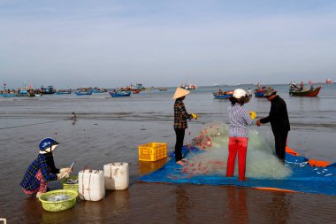 Tam Duong sahilinde balık ağlarını tamir eden balıkçılar. Vung Tau. Vietnam. 