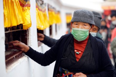 Tibetli bir kadın Bodhnath Stupa çevresinde dua tekeriyle hacca gidiyor.. 