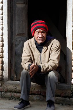 Nepalli adam evinin önünde oturuyor.. 