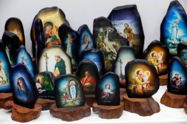 Shop selling religious christian items. Painted stones religious images.  Ho Chi Minh City. Vietnam. 