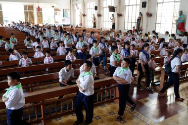 Pazar sabahı Katolik ayininde Hıristiyan çocuklar. Chau Doc Kilisesi. Vietnam. 
