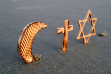 Hristiyanlık, İslam, Musevilik 3 tek tanrılı din. Yahudi Yıldızı, Haç ve Hilal: Kumda dinler arası semboller. 
