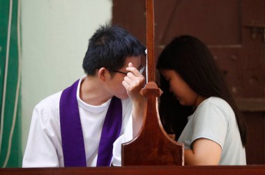 Aziz Francis Xavier Kilisesi. Katolik rahip itirafları dinliyor. Ho Chi Minh şehri. Vietnam. 