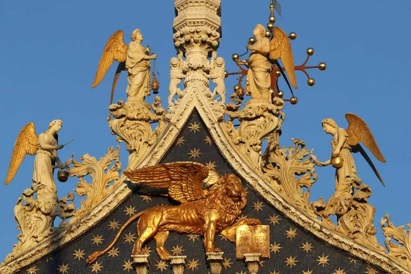 San Marco Bazilikası. Venedik ve Aziz 'in sembolü olan Kanatlı Aslan' ın üstündeki meleklerle Aziz Mark. Altın kanatlı aslan heykeli ve bazilika cephesinde melekler. Venedik. İtalya. 