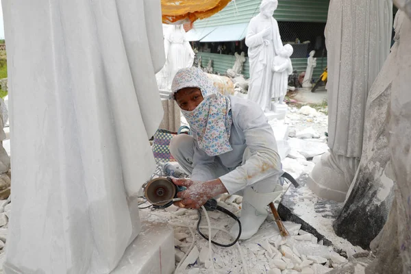 Bir zanaatkar granit atölyesinde Bakire Meryem heykeli oyuyor. Ba Ria. Vietnam. 