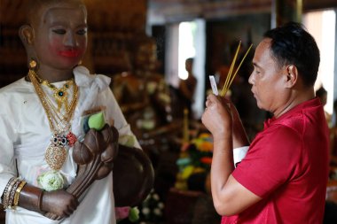 Wat Phnom Daun Penh Budist tapınağı. Dua eden adam. Phnom Penh. Kamboçya. 