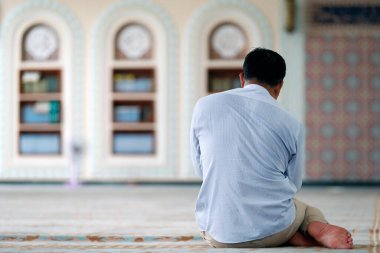 Al-Serkal Camii. Mulsim, camide halıda oturmuş Kuran okuyor. Phnom Penh. Kamboçya. 