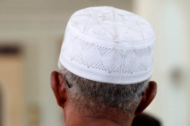 Al-Serkal Camii. Müslüman bir adam elinde kufi şapkasıyla dua ediyor. Phnom Penh. Kamboçya. 