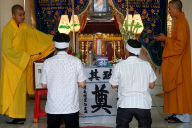 Linh Son Co Tu buddhist temple. Funerals. Men praying with monks.  Vung Tau. Vietnam. 