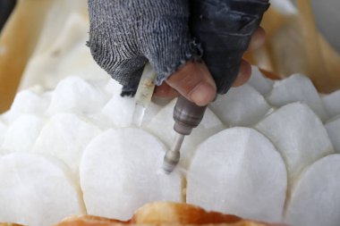 Quan Am, merhametin Bodhisattva 'sı ya da Merhamet Tanrıçası. Heykel. Bir zanaatkar granit atölyesinde Budist heykeli oyuyor. Vung Tau. Vietnam. 