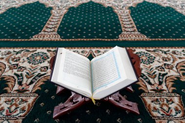 Mescid Al Ehsan camii. Tahta tezgahta Kur 'an açın. Vietnamca çeviri. Yeşil halılı dua salonu. Chau Doc. Vietnam. 