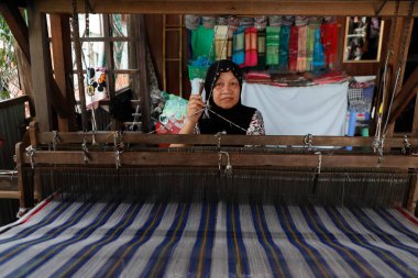 Geleneksel el dokuma tezgahı. Yerel Müslüman kadın özenle renkli eşarplar dokuyor. Chau Doc. Vietnam. 