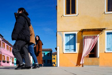 Multi colored houses in Burano village. Chinese tourists.  Italy. 