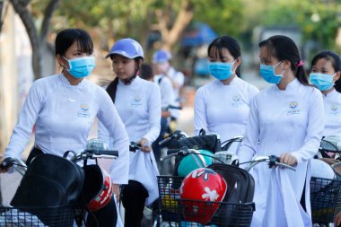 Okula giderken Ao Dai 'de giyinen öğrenciler. Cai Be. Vietnam. 