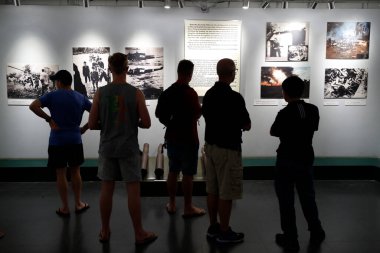 Savaş Kalıntıları Müzesi. Savaştan şok edici fotoğraflara bakan ziyaretçiler. Ho Chi Minh Şehri. Vietnam. 