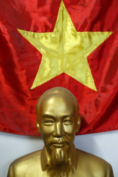 Statue of leader Ho Chi Minh and communist vietnamese flag.  Ho Chi Minh City. Vietnam. 