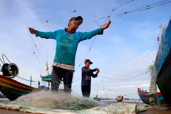 Güney Çin Denizi. Balıkçılar balıkçı ağları üzerinde çalışıyor
