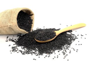 Tahta kaşık ve kenevir torbasında siyah susam. beyaz arkaplanda izole edilmiş.