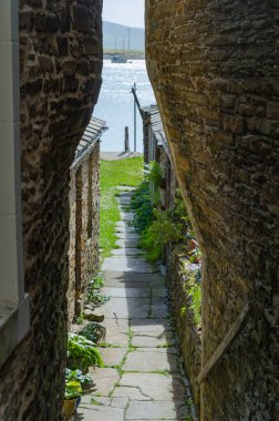 A view of the sea through a narrow alley in Stromness, Orkney. clipart