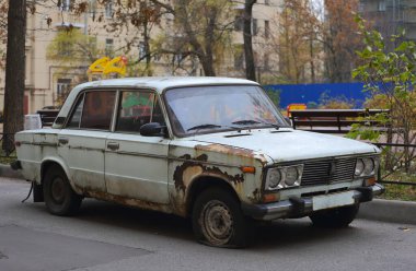 Eski paslı, beyaz Sovyet yolcu vagonu bir iskan binasının avlusunda, Zanevsky Prospekt, St. Petersburg, Rusya, Ekim 2021